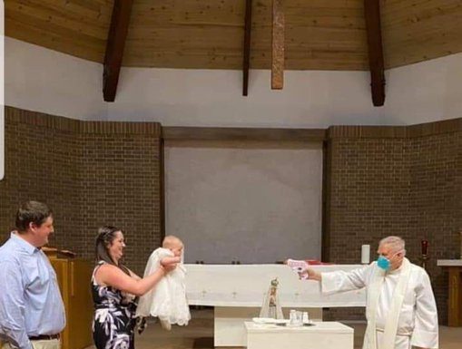 Priest performs socially-distanced baptism on baby using water pistol