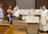 Priest performs socially-distanced baptism on baby using water pistol