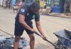 Aspiring MP John Dumelo helps clean choked gutters in his constituency.
